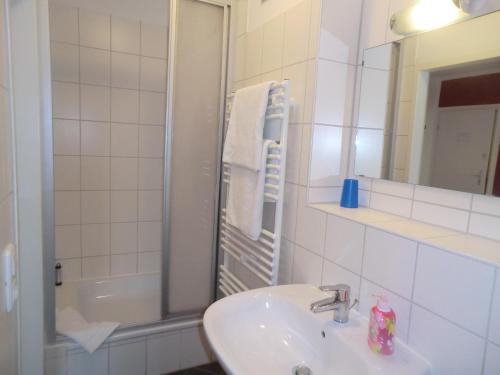 慕尼黑海尔顿潘森酒店的一间带水槽、淋浴和镜子的浴室
