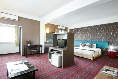 曼谷彩虹精品酒店的酒店客房,配有床和电视