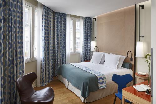 巴黎贝尔阿米酒店的配有一张床和一把椅子的酒店客房