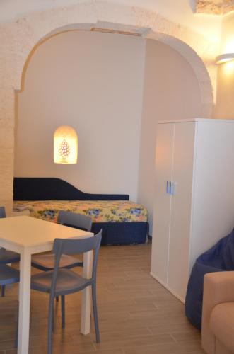 奥斯图尼LA CASETTA 2.0的配有一张床和一张桌子及椅子的房间
