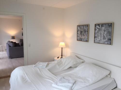 哥本哈根CPH Lux apartm, 2 FULL BATHROOMS 2th的白色卧室内的一张白色床,配有灯