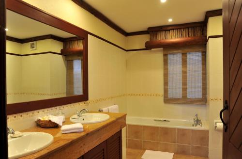 Tsavo凯丽古娜斯瑞娜狩猎山林小屋的浴室设有2个水槽、浴缸和镜子
