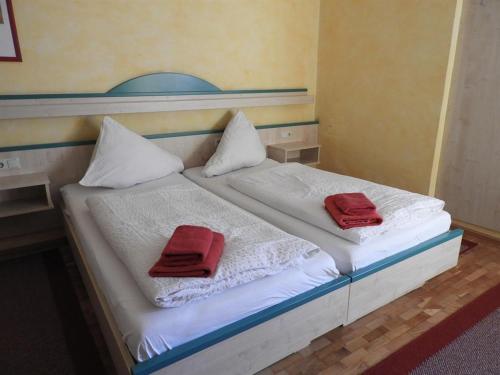 克拉根福Gasthof Schlosswirt的床上有两条红色毛巾
