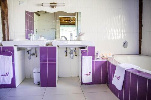 PhokengTshiBerry Bed & Breakfast的紫色和白色的浴室设有两个水槽和一个浴缸