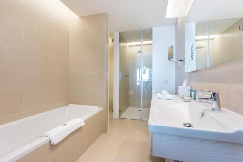 拉戈斯Palmares Beach House Hotel - Adults Only的白色的浴室设有浴缸和水槽。