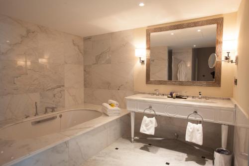 科纳克里卡马耶尼帕尔姆酒店的带浴缸、水槽和镜子的浴室