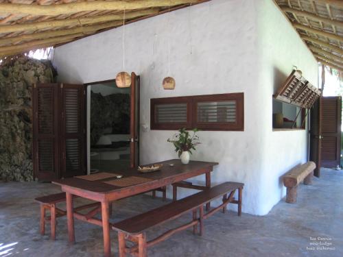 拉斯加勒拉斯La Cueva Eco-Lodge的木桌和长凳位于客房前