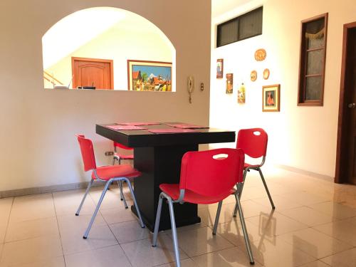 瓜亚基尔Casa Canelos的一间设有桌子和四把红色椅子的房间