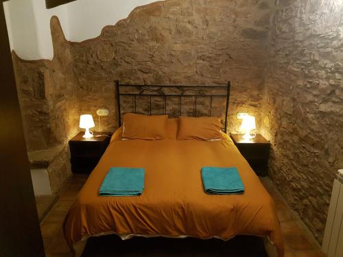 TagamanentLes Casetes del Congost Vilatge Resort Barcelona的卧室配有一张石墙床