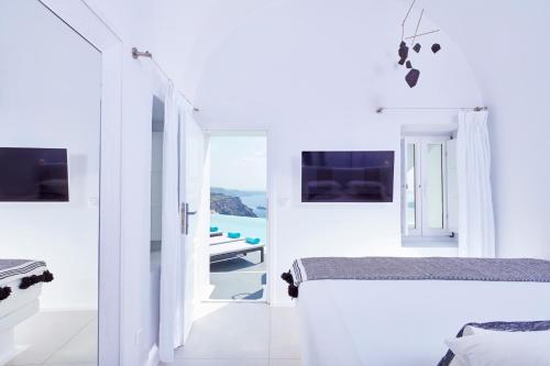 费拉大都会套房 - 世界小型豪华酒店的一间设有两张床的白色卧室,享有海景