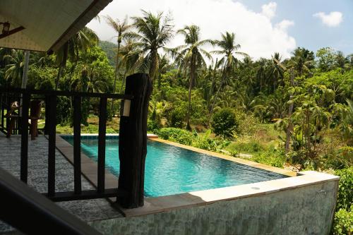 通萨拉仙境治疗中心度假村的棕榈树度假村内的游泳池