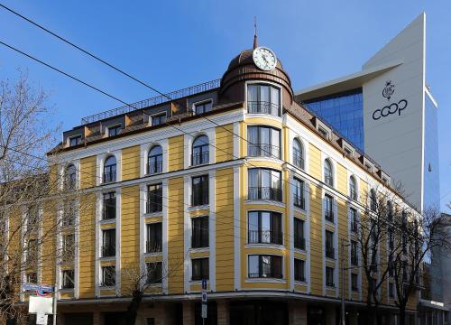 索非亚索菲亚库奥普酒店的黄色的建筑,上面有钟