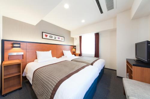 MYSTAYS 堺筋本町酒店客房内的一张或多张床位