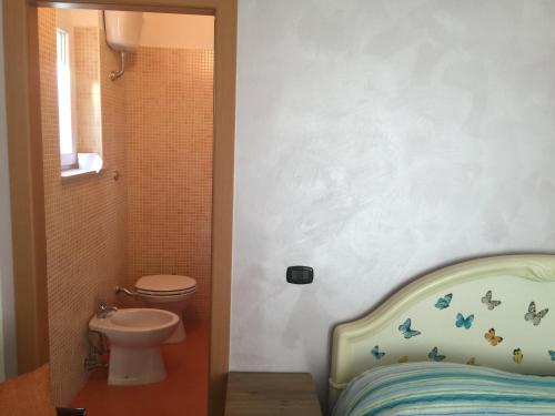 科拉托Villa Valeria B&B的浴室设有床、卫生间和水槽。