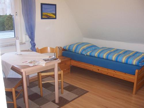 吕讷堡Haus am Roseneck的小房间设有一张床和一张桌子