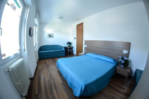 Zelbio国民酒店的一间卧室配有蓝色的床和沙发