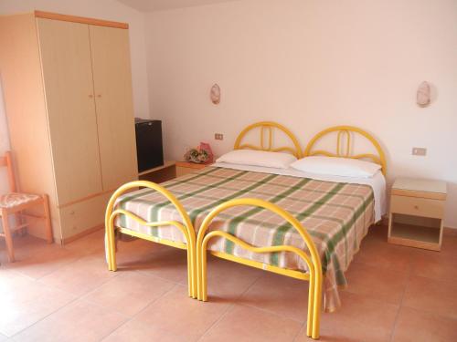 圣尼科拉阿尔切拉Albergo Il Brillantino的一间卧室配有一张带绿色和黄色床罩的床。