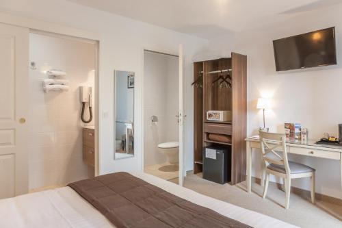TennieLogis Auberge le petit pont的酒店客房设有一张床、一张书桌和一间浴室。