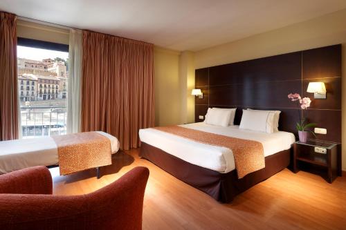塞哥维亚欧洲之星水道桥广场酒店的酒店客房设有两张床和窗户。
