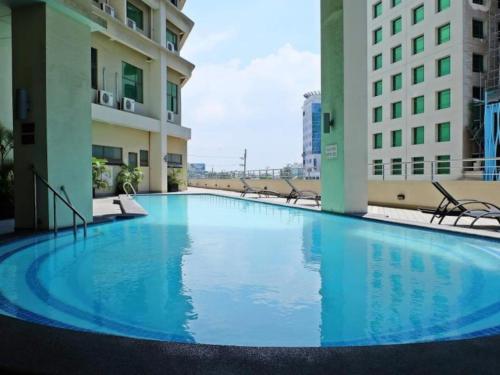 宿务曼德闰普拉扎酒店的大楼中央的一个大型蓝色泳池
