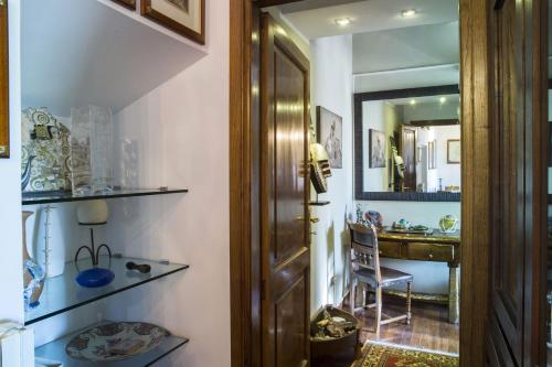 维泰博Antica Dimora San Pellegrino的走廊上设有门、椅子和镜子