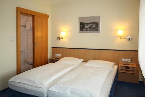 BalveHotel garni Zum Drosten的一间带2张白色床的卧室和一间浴室