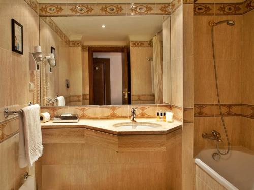 里斯本里斯本特里姆酒店的一间带水槽和大镜子的浴室