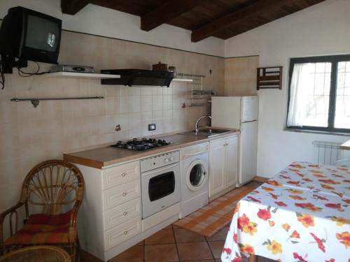 卡梅罗塔码头Villino Iolanda的厨房配有炉灶和洗衣机。