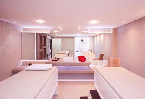 皮拉图巴Hotel Paraiso的客房设有两张床、一个水槽和镜子