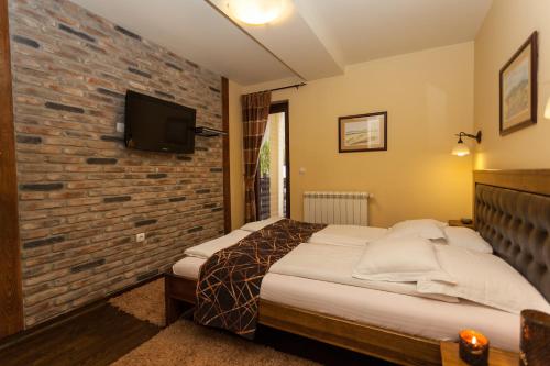 兹拉蒂博尔巴耶克旅馆的一间卧室设有一张床和砖墙