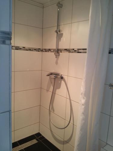 诺尔贝克Vakantiewoning Kleijnen的浴室内带软管的淋浴