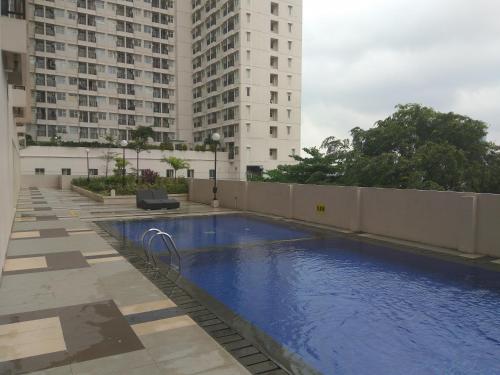 德波DSR Apartment Margonda Residence 5的一座高楼建筑中间的游泳池