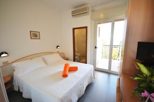 切塞纳蒂科Hotel Apollo的一间卧室配有一张白色的床,上面有橙色的物品