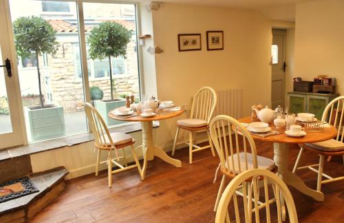 Monk FrystonThe Barn的一间带2张桌子和椅子的用餐室以及窗户。