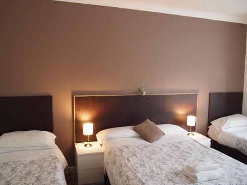 梅登黑德金斯伍德酒店的一间卧室设有两张床和两张台灯。