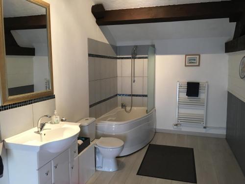 Saulgond17 St Romain的带浴缸、卫生间和盥洗盆的浴室