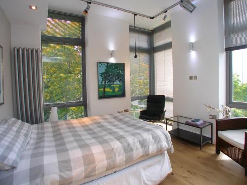 伦敦Saint Anns的一间卧室配有一张床、一把椅子和窗户。