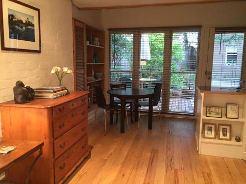 墨尔本Garden Cottage St Kilda的用餐室配有桌椅和桌子
