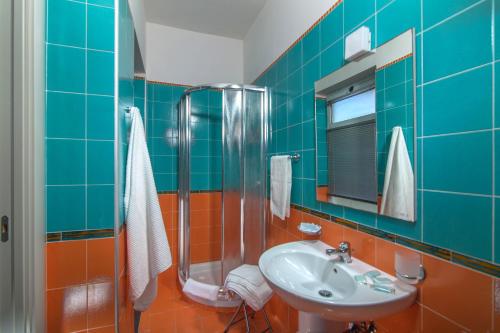 韦兰迈尔漫画别墅的蓝色瓷砖浴室设有水槽和淋浴
