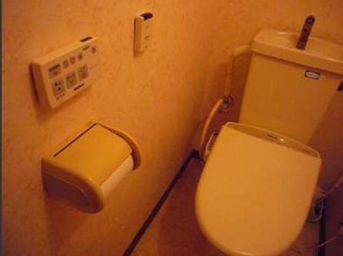 松本诗意酒店的墙上设有带卫生间和饮水机的浴室