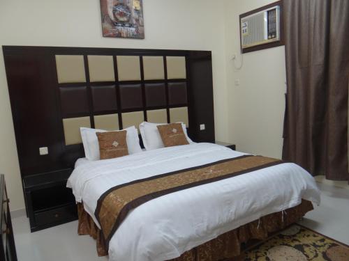 代瓦西尔干河Royal Home Furnished Apartments的一间卧室配有一张大床和大床头板
