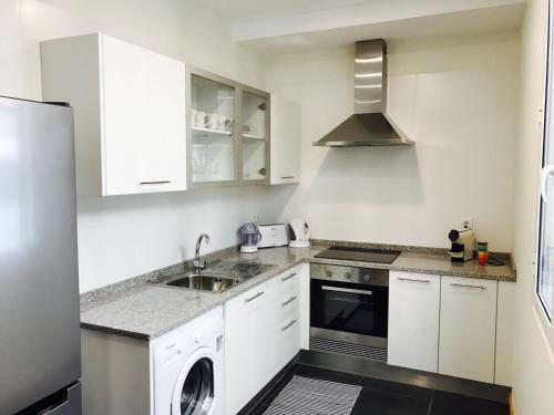 丰沙尔Apartamentos da Sé Catedral的白色的厨房配有水槽和洗碗机