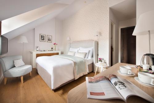布拉格设计聂鲁达酒店的一间卧室配有一张床和一张桌子及一本书