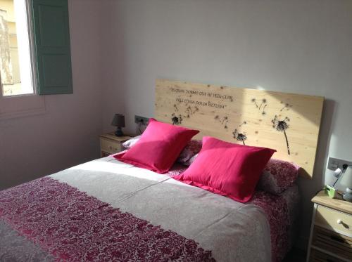 菲格拉斯Apoteka apartaments的一间卧室配有一张带两个粉红色枕头的床