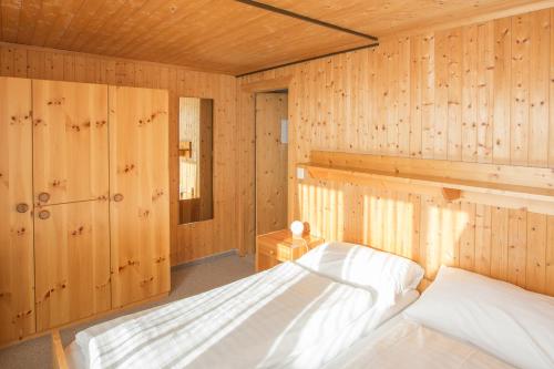 弗利姆斯拜格豪斯纳根斯旅舍的一间带木墙的卧室和一张位于客房内的床