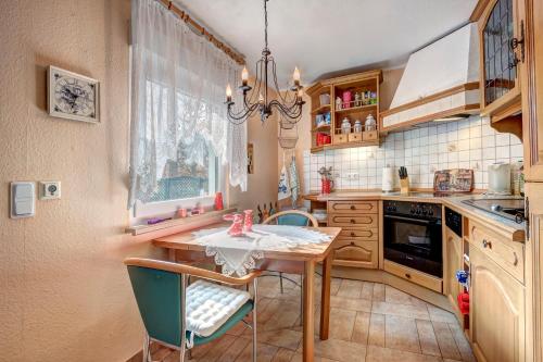 科尔平塞Ferienhaus Matthies的厨房配有桌椅和吊灯。