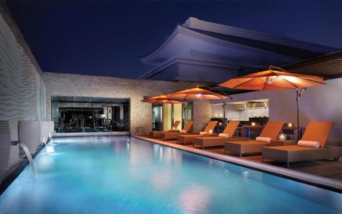 迪拜迪拜韩亚酒店的一个带椅子和壁炉的游泳池