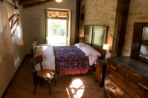 MontegiorgioCasa della Strega的一间卧室配有一张床、一个梳妆台和一扇窗户。