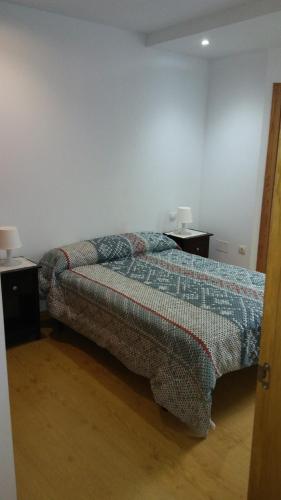 比韦罗Apartamento con balcón的一间卧室配有床和2个床头柜