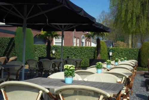 Riethoven仕乐途餐厅酒店的一排桌子,椅子和雨伞